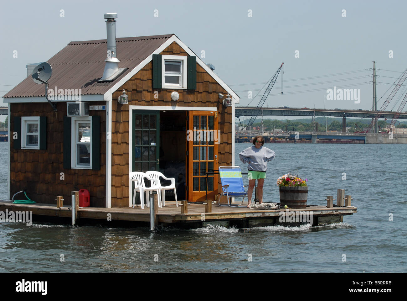 A houseboat motors through New Haven Harbor in Long Island Sound in New Haven Connecticut USA Stock Photo