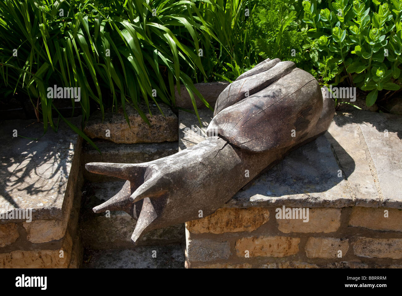 Large rough carved wooden snail on a garden wall Stock Photo