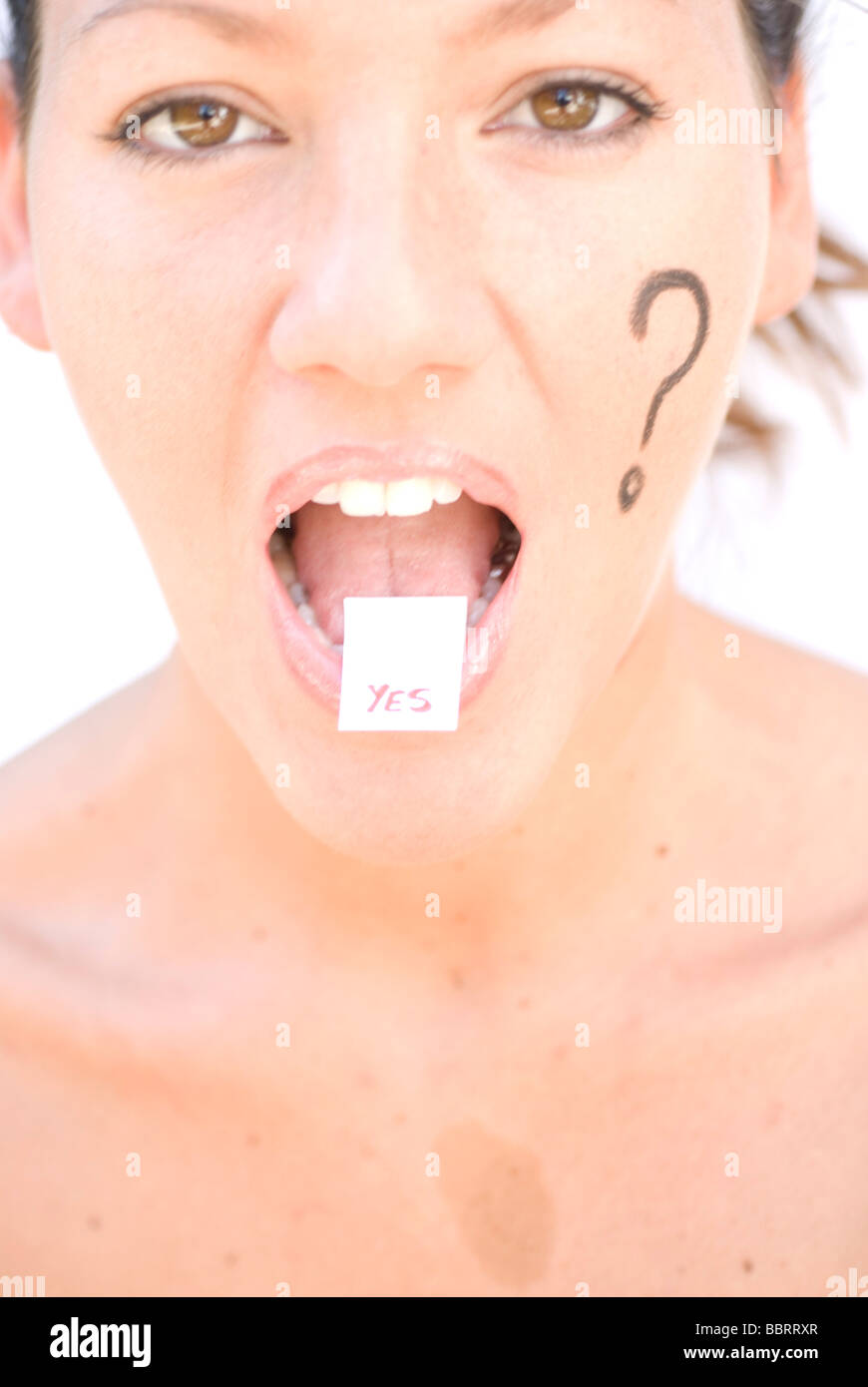 Question mark simbol painted in woman´s face and answer Yes on her tongue Stock Photo