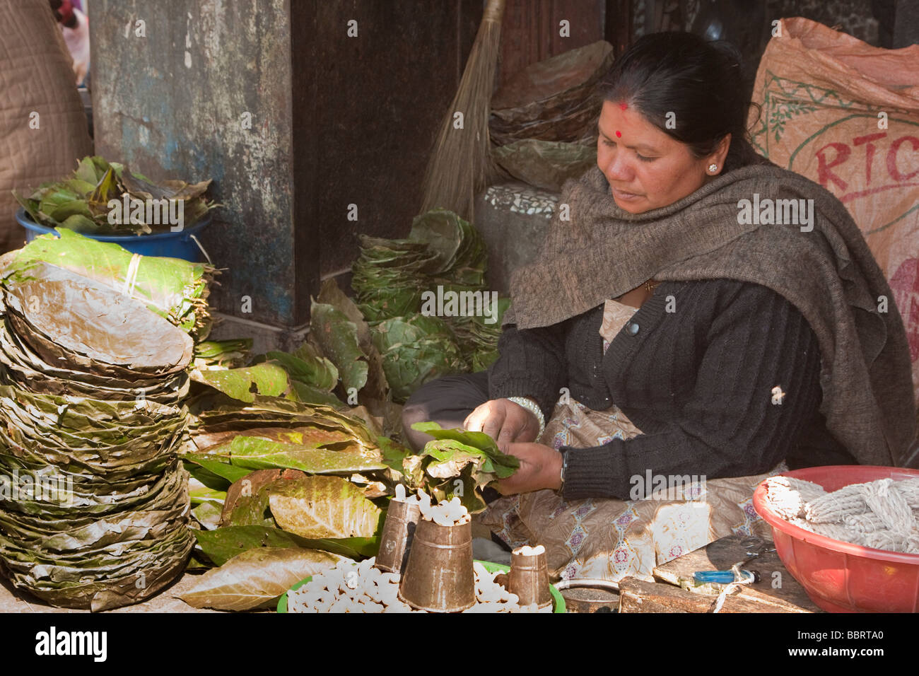 Durbar Square Market, Kathmandu, Nepal. Market vendor lady selling sal leaf bowls for temple food offerings. Stock Photo