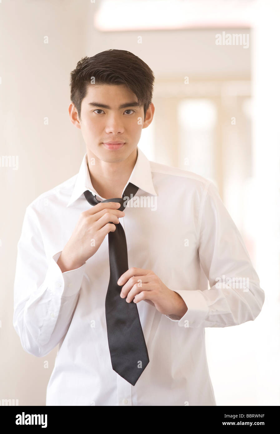 Asian Man Dressing for Work Stock Photo