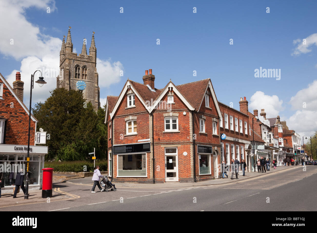 St Mildred's Parish Church clock tower behind shops on High Street in