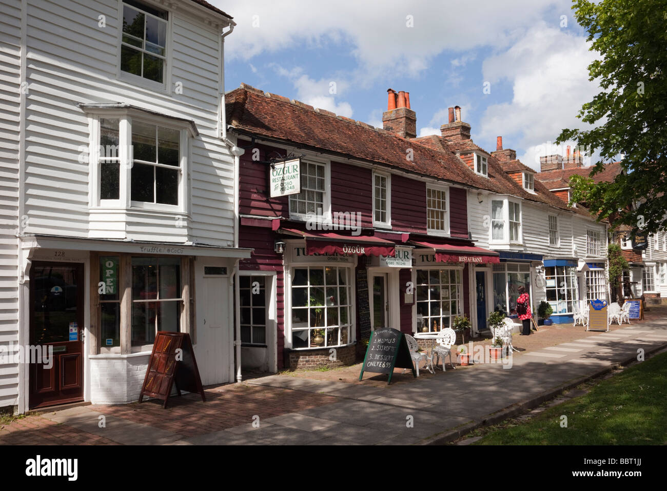 Tenterden Kent England UK  Cafe and small shops in 15th to 18th century buildings on tree-lined High Street in Wealden town Stock Photo