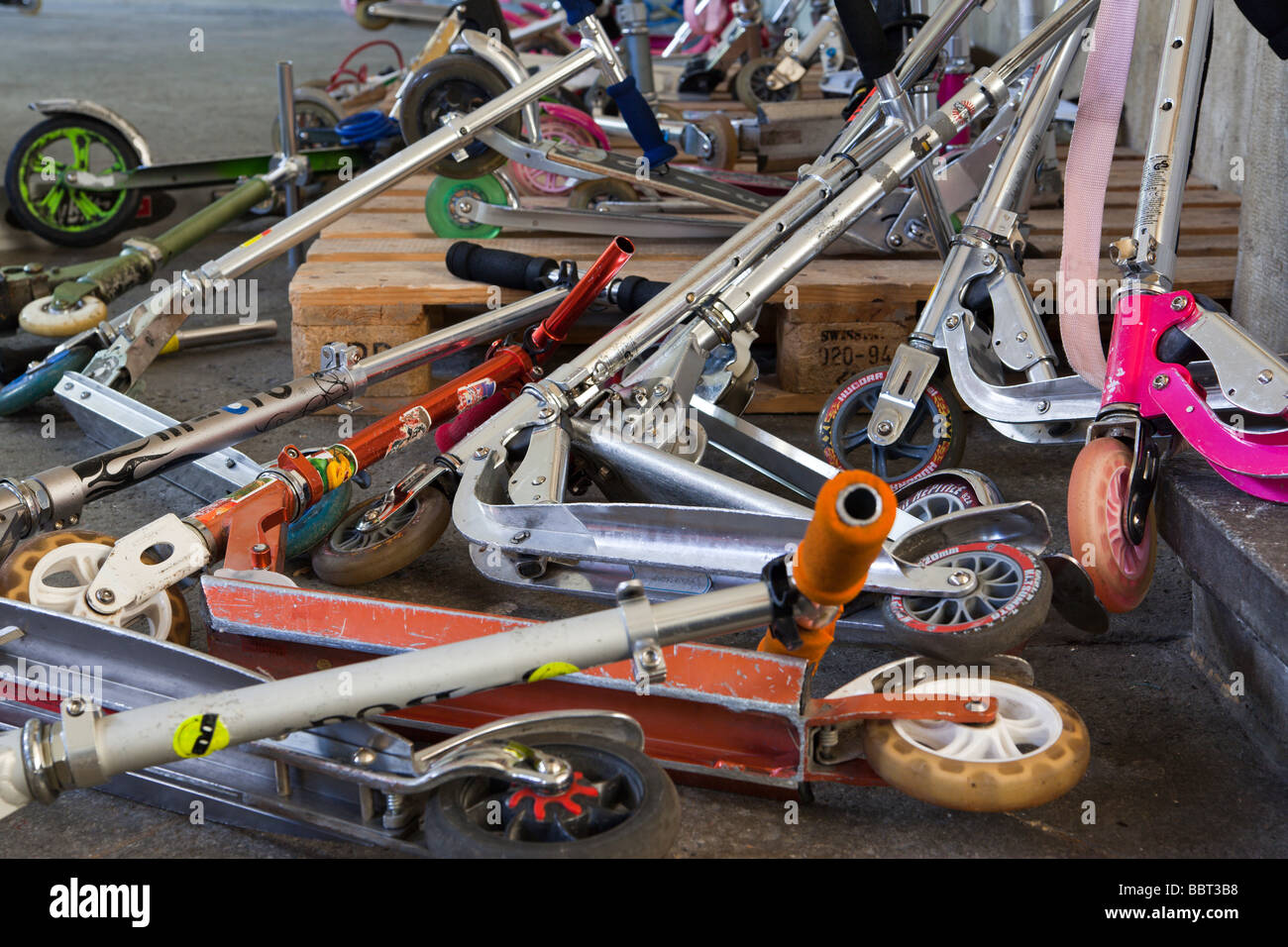 Children s scooters piled in a stack at school Stock Photo Alamy
