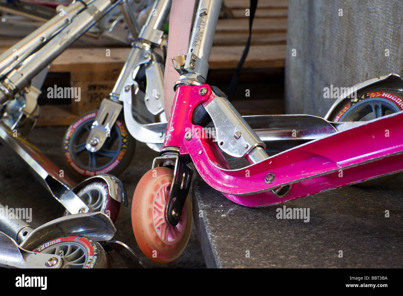 Children s scooters piled in a stack at school Stock Photo Alamy