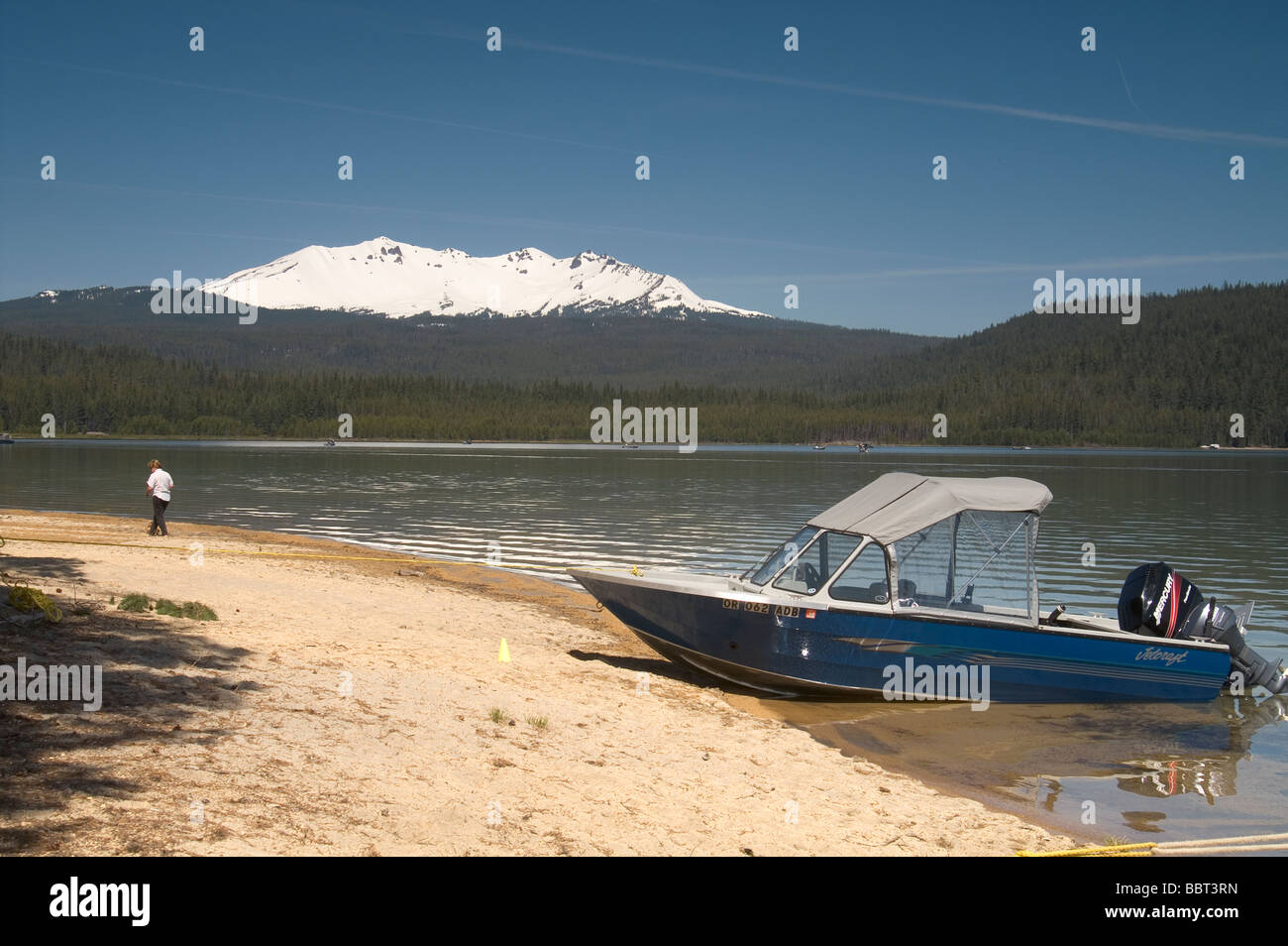 Boat and Boy Diamond Peak Oregon form Crescent Lake Stock Photo