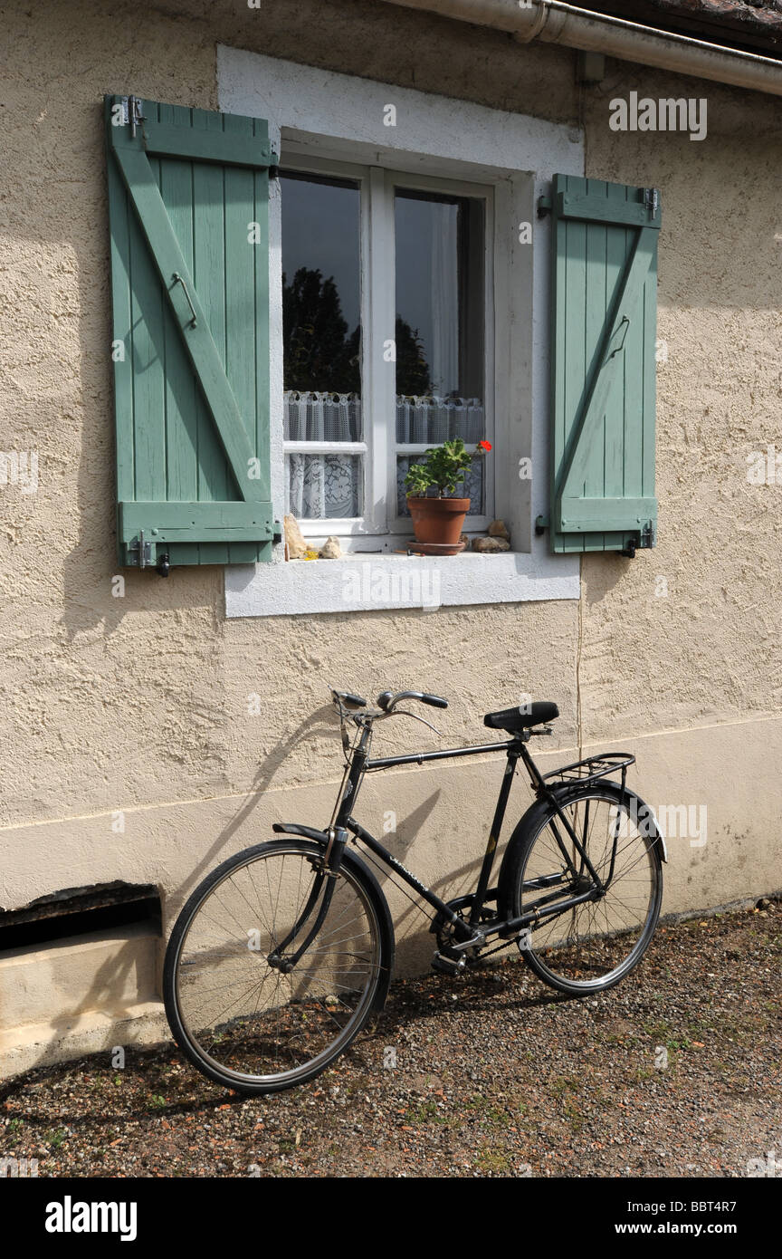 Bicycle outside French cottage window Dordogne France Stock Photo