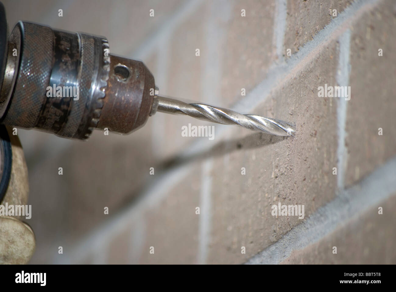 Drilling a hole in a brick wall with a masonry drill Stock Photo