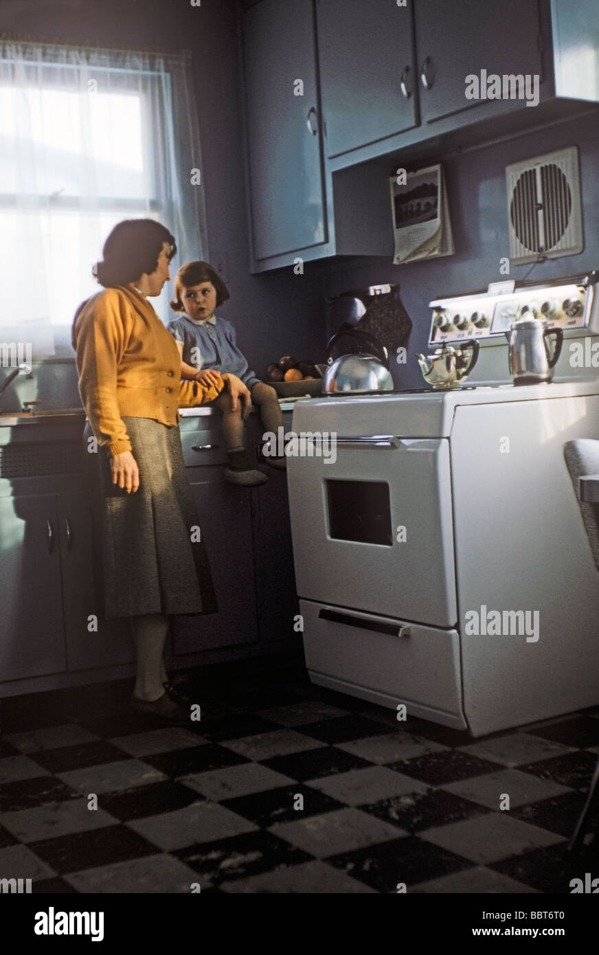 Mother and toddler daughter in smart new kitchen, Canada 1955 Stock Photo