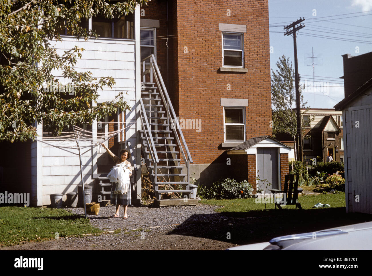 Woman hangs washing outside her Canadian duplex 1957 Stock Photo