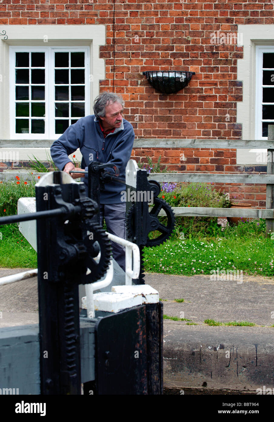 Lock keeper opening one of the Tyrley Lock gates Stock Photo Alamy