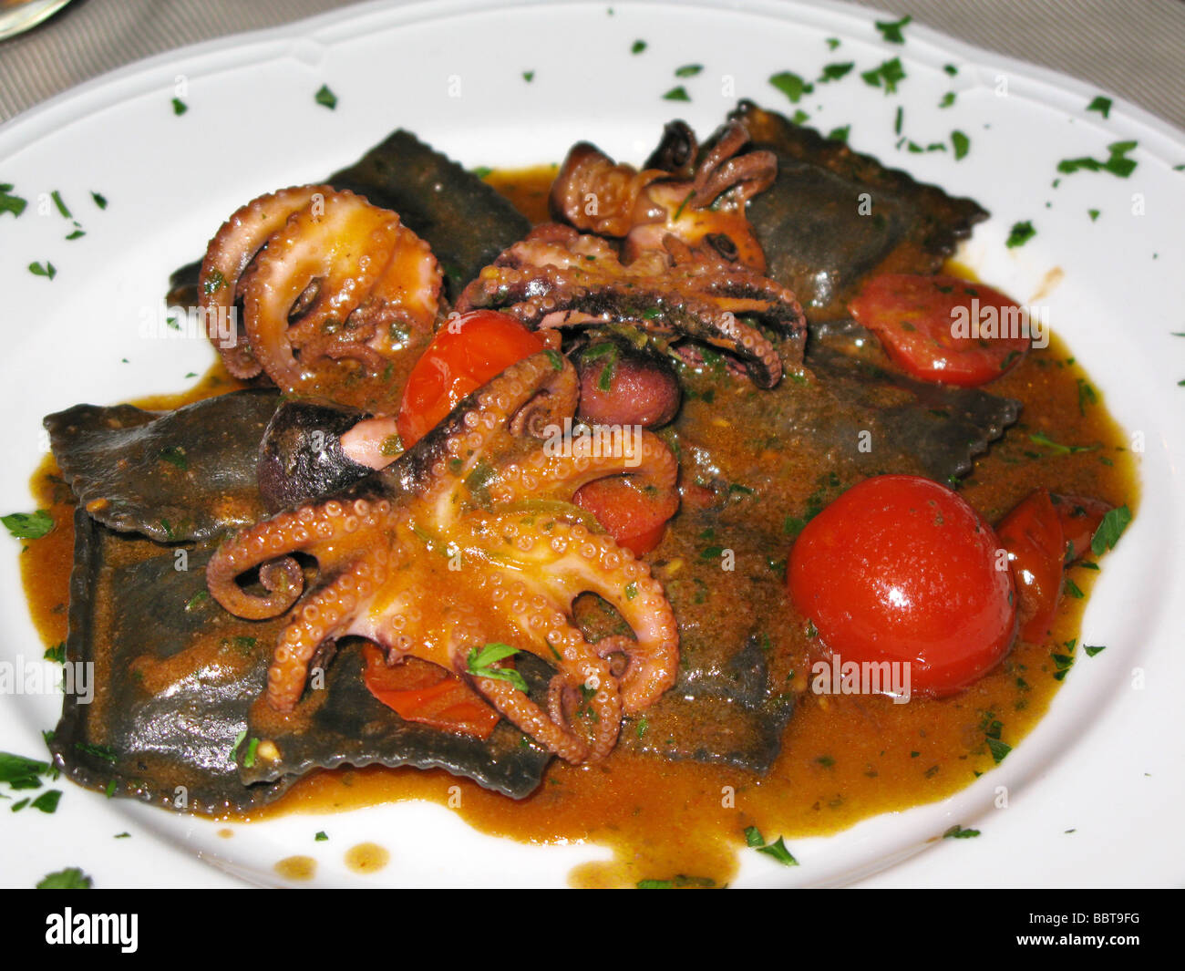Spaghetti with squid ink and octopus, Italy Stock Photo - Alamy