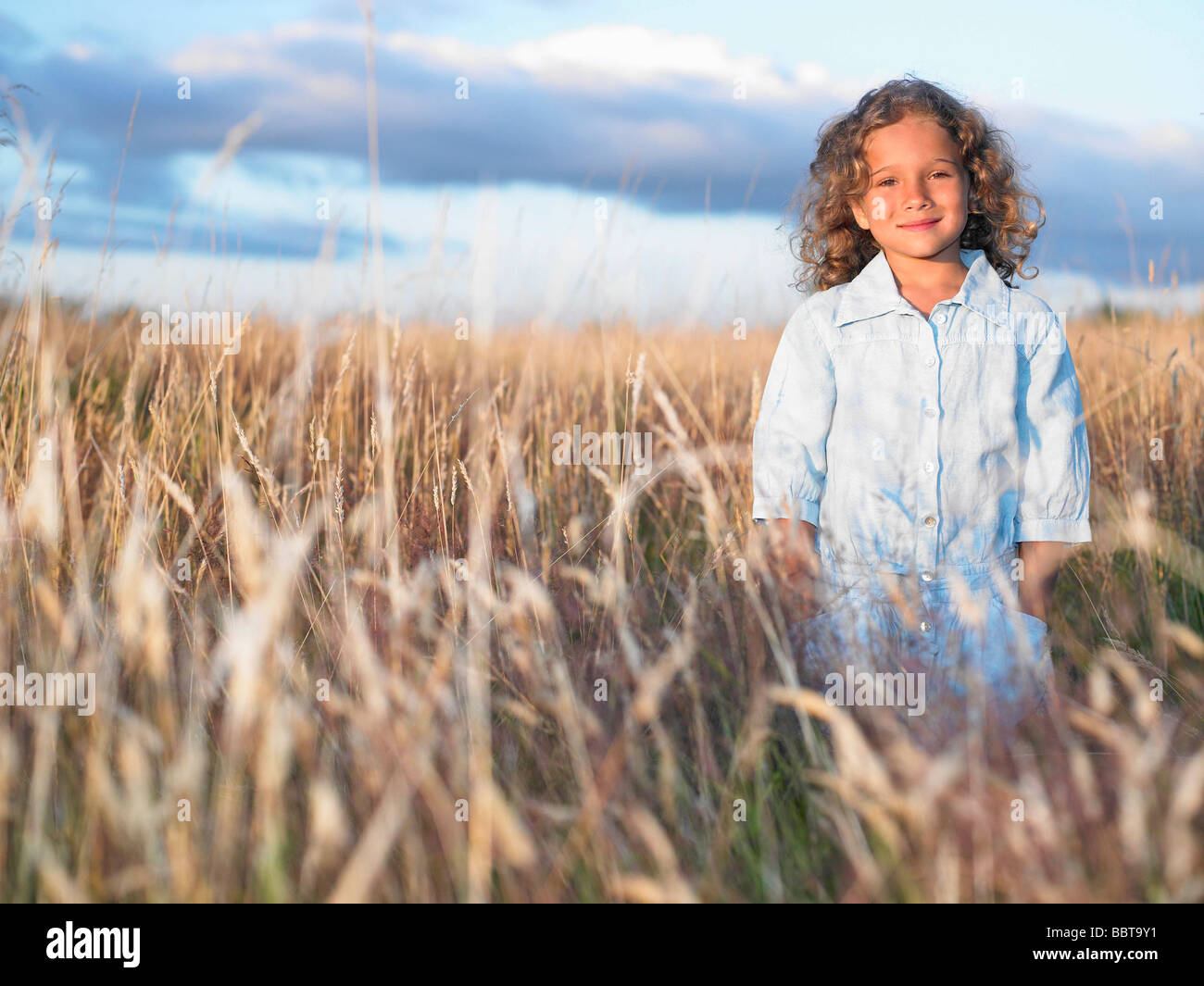 Girl standing in a field Stock Photo - Alamy