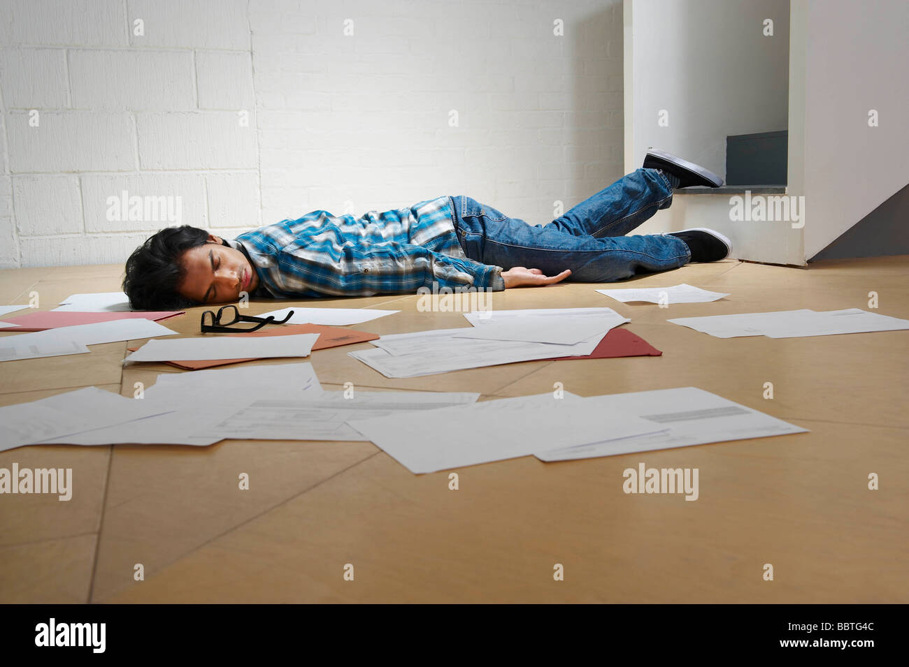 Young Man Lying On Office Floor Stock Photo Alamy