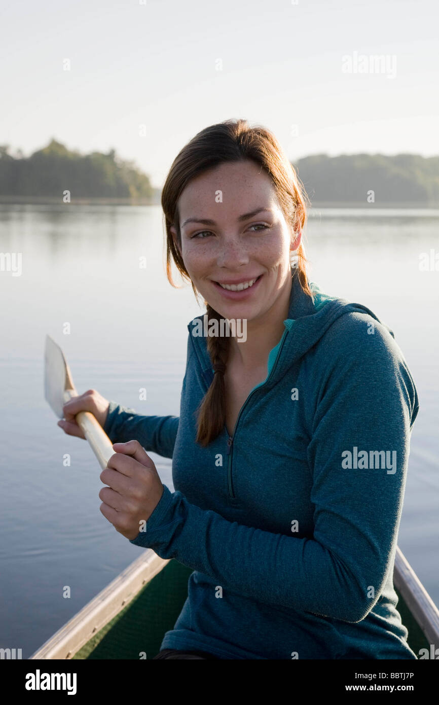 Woman canoeing in morning light Stock Photo Alamy