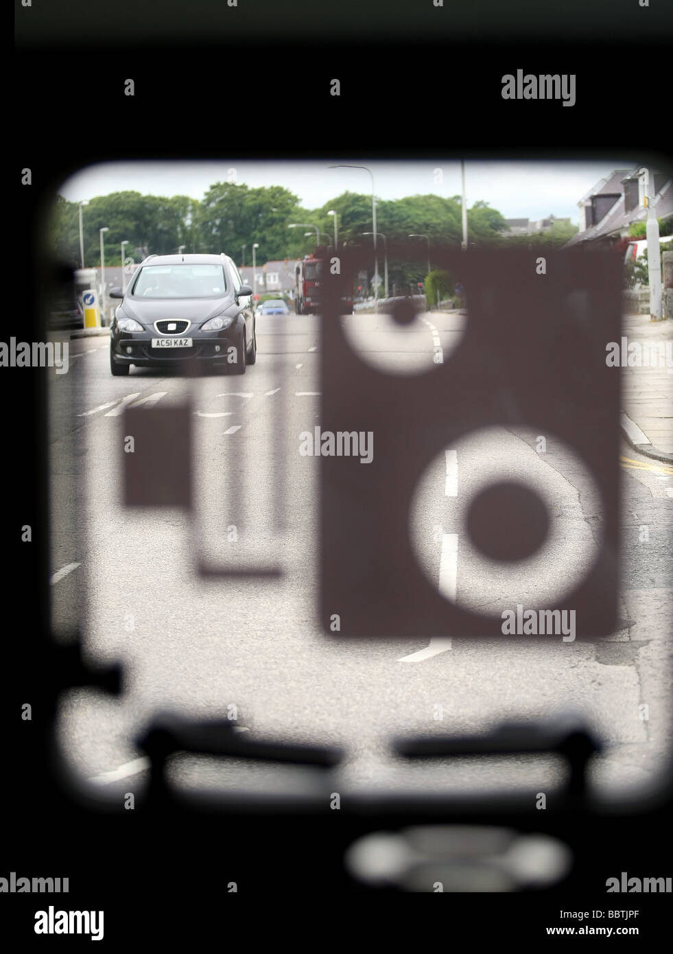 A view through the window of a Safety Camera van showing the operator's view with the window closed and speed camera symbol Stock Photo