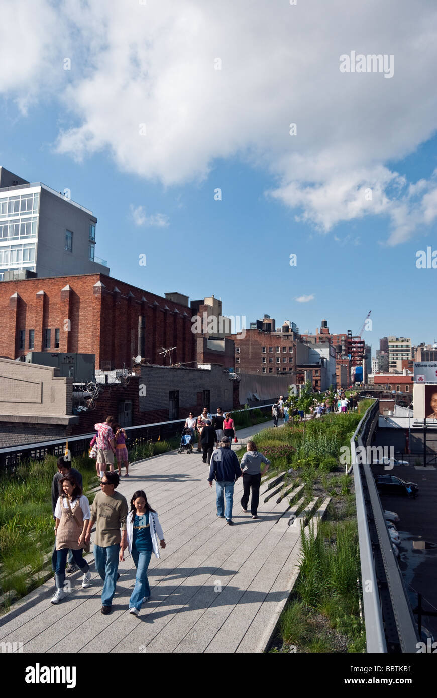 pedestrians strolling on the walkway of the elevated High Line park on a magnificent spring Sunday, in Manhattan, New York City Stock Photo