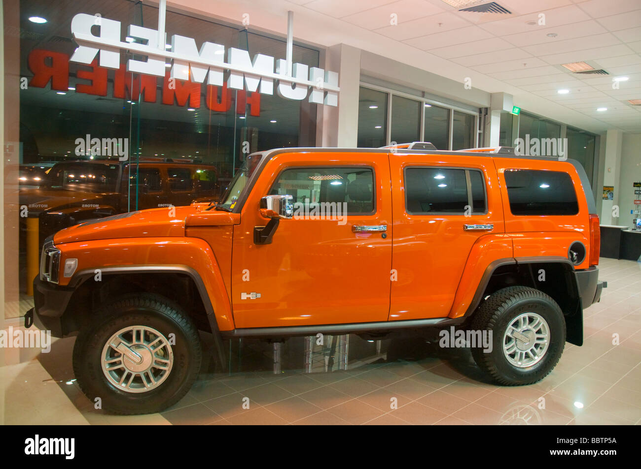 Orange civilian model Hummer in showroom Stock Photo - Alamy