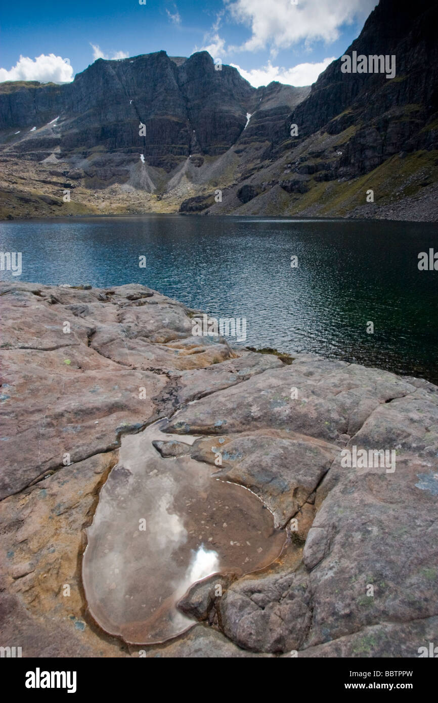 Triple buttress and corrie lochan, Ben Eighe, Torridon, with a heart shaped pool in the foreground reflecting the sun Stock Photo