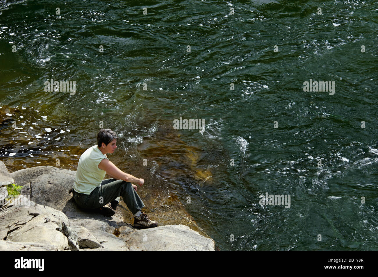 Woman Sitting on Boulder Beside the Little River in the Great Smoky Mountains National Park Tennessee Stock Photo