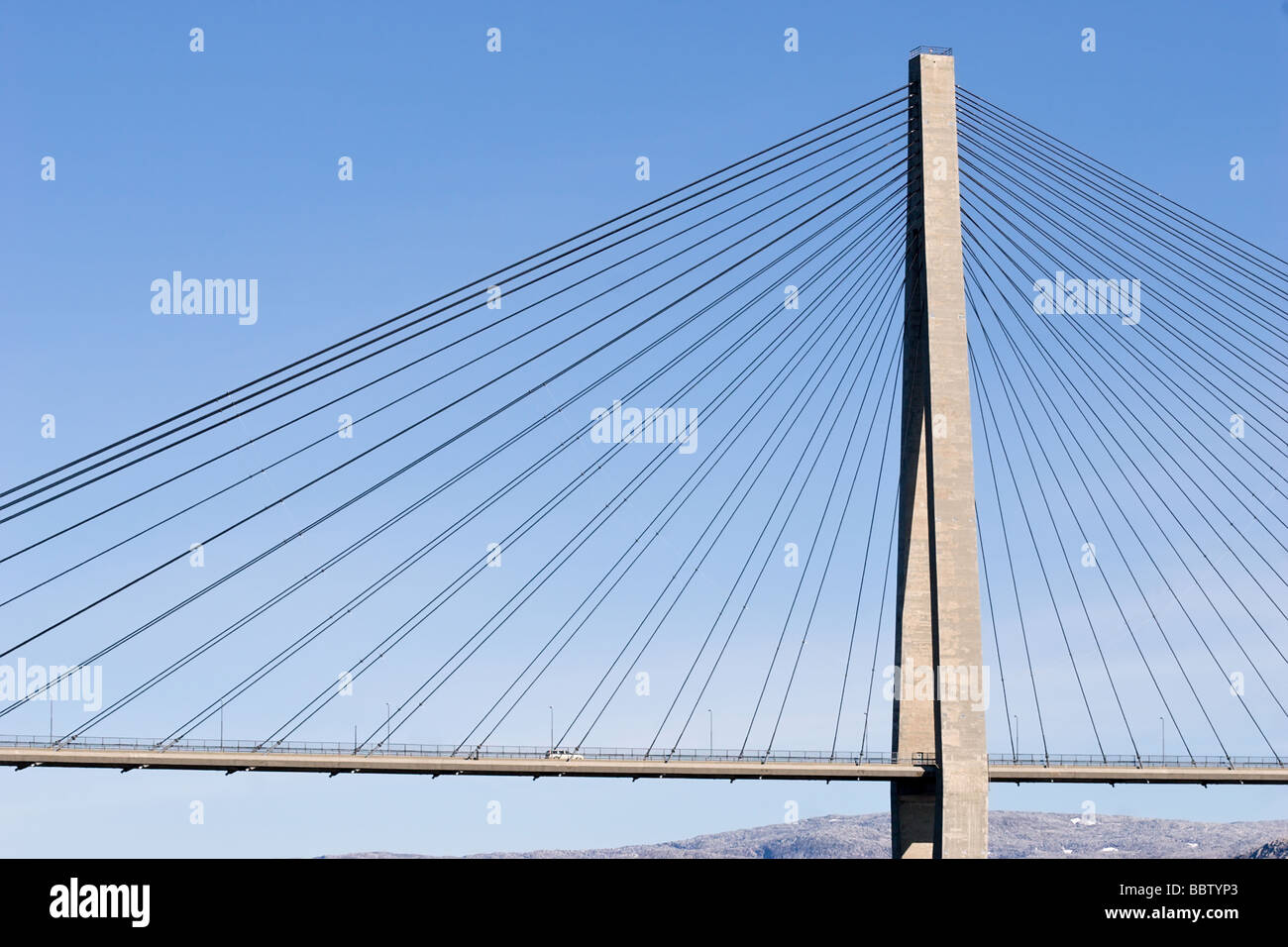 huge grey suspension bridge closeup on blue sky background Stock Photo