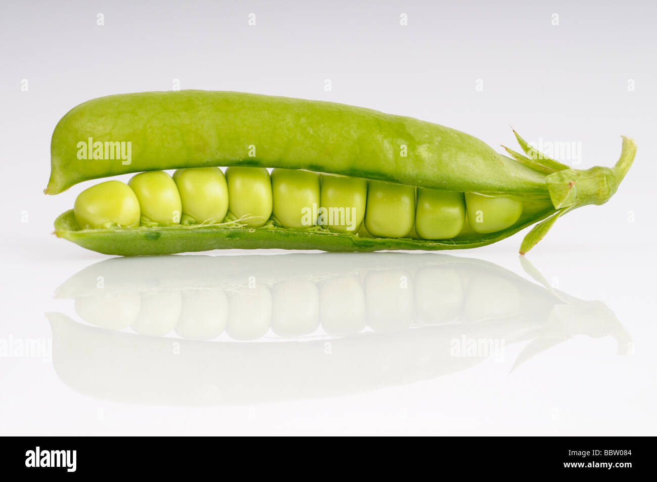 Fresh garden peas in a pod against a white background Stock Photo
