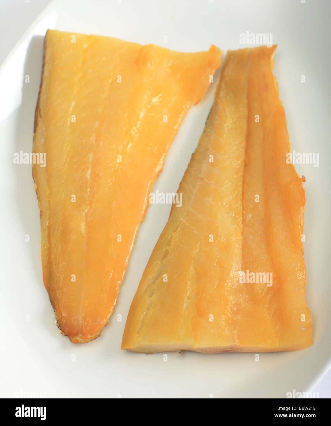 Two fillets of smoked haddock on a white plate Stock Photo