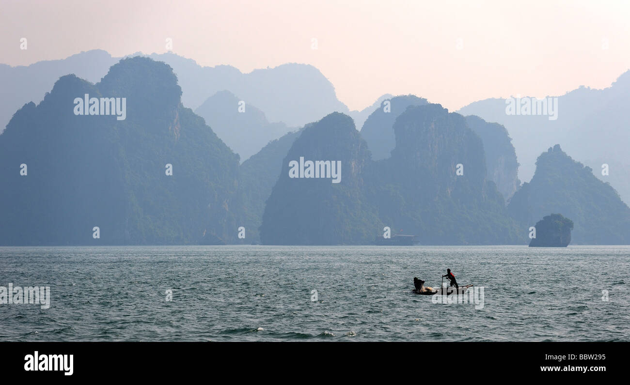 Rock formations with a rowboat, Halong Bay, Hanoi, Southeast Asia Stock Photo