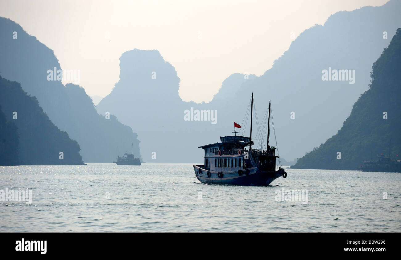 Ship in front of rock formations, Halong Bay, Hanoi, Southeast Asia Stock Photo