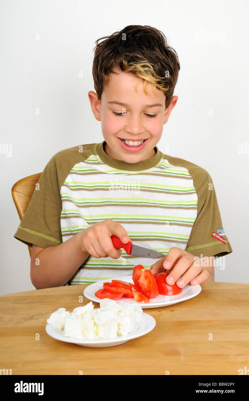 Boy cutting a tomato for a salad Stock Photo