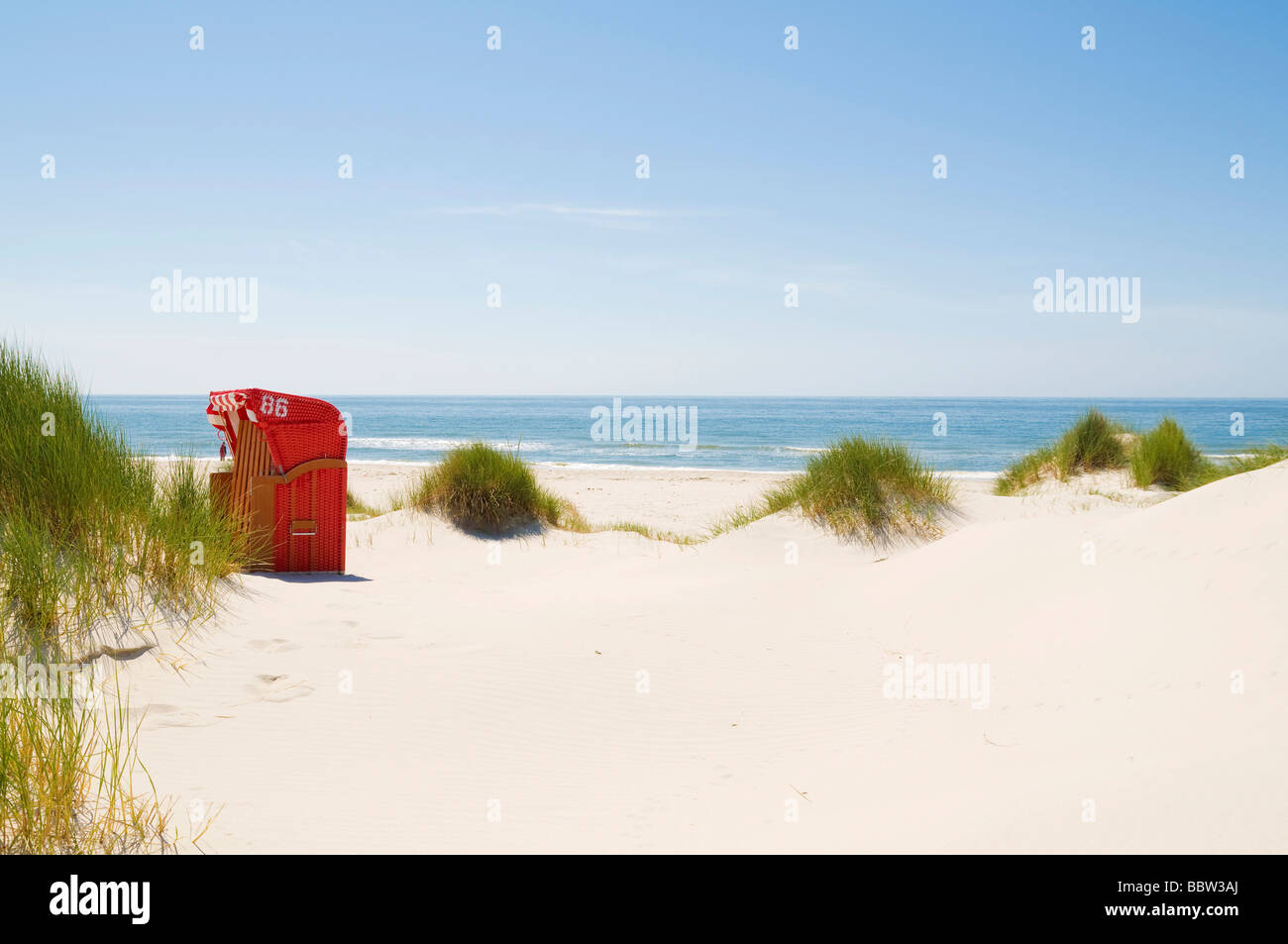 Red beach chair in the dunes and blue sky, Amrum, North Sea, Germany, Europe Stock Photo