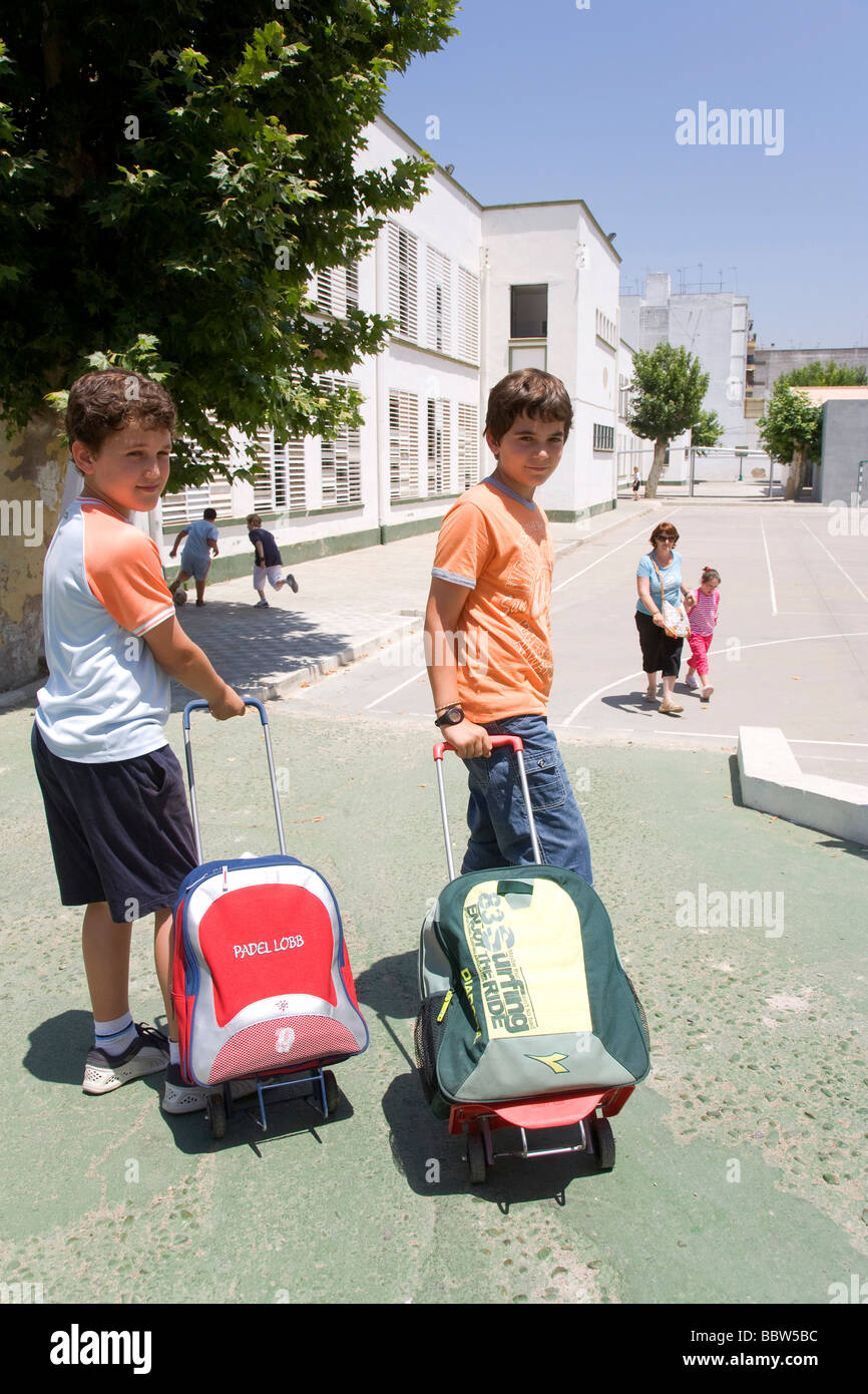School children leaving Salesiano Satisima Trinidad Primary School, Seville, Andalusia, Spain, Europe Stock Photo