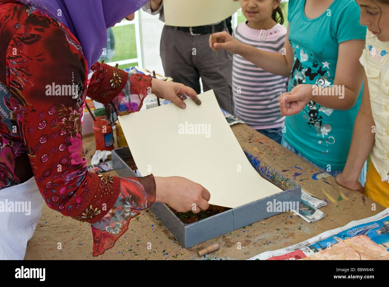 TURKISH ART TEACHER TEACHING TRADITIONAL EBRU ART TO THE SCHOOL KIDS Stock Photo