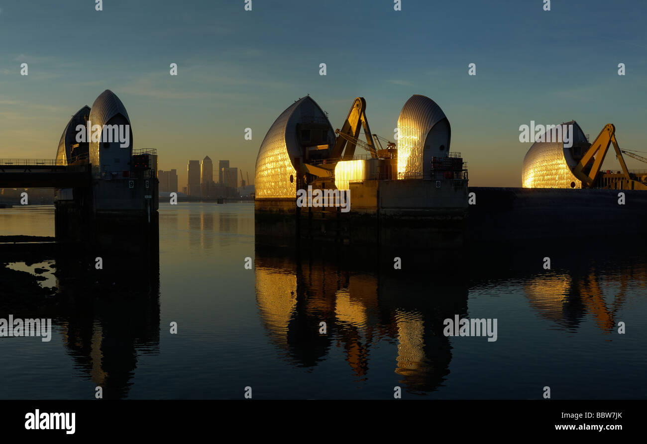 Thames Barrier in reflection on a blue River Thames with Canary Wharf ...