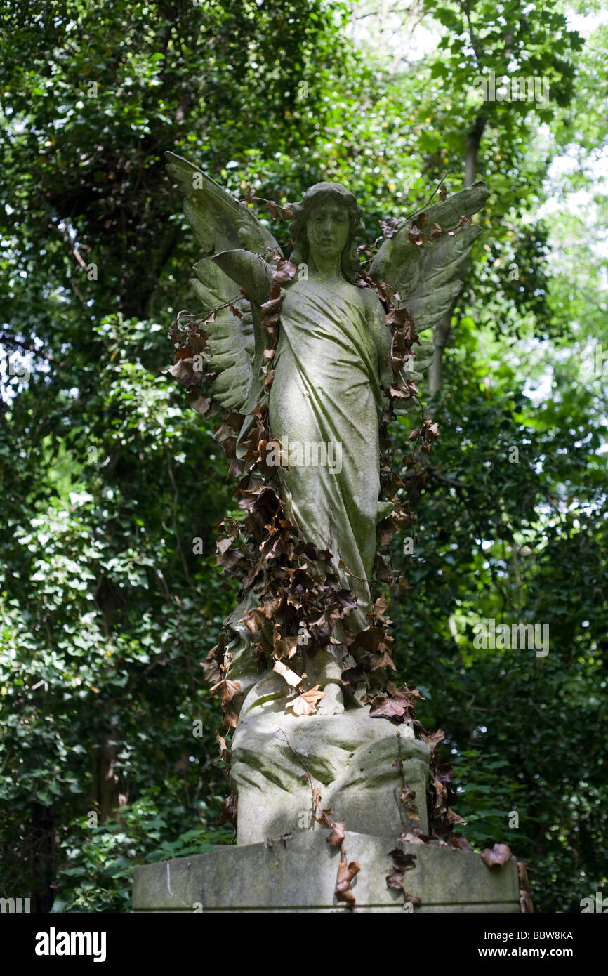 Overgrown Victorian architectural angel above a gravestone, now covered