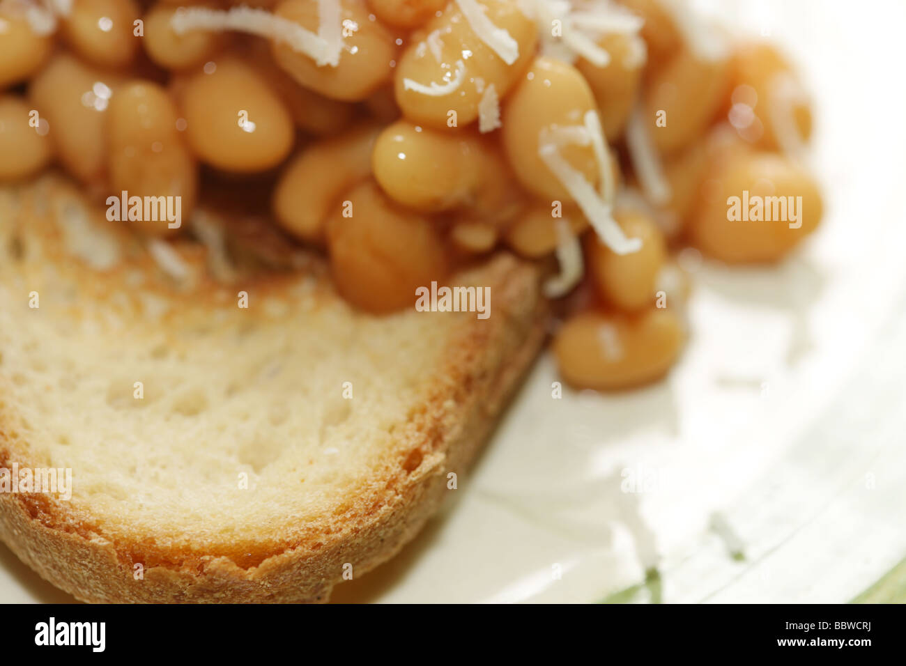 Baked Beans and Parmesan Cheese on Bruschetta Stock Photo