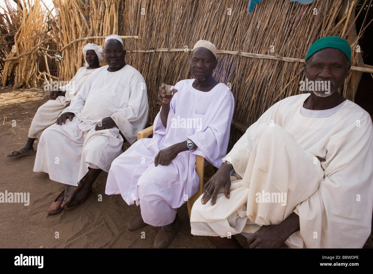 Four Sudanese gentlemen sit in the shade in the 4 sq km Abu Shouk refugee camp in Al Fasher, North Darfur, Sudan Stock Photo