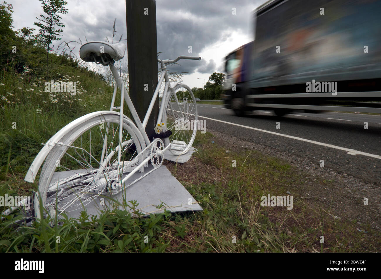 A Ghost Bike - a white painted cycle chained to the spot where a cyclist was killed in a road accident on the A23. Stock Photo