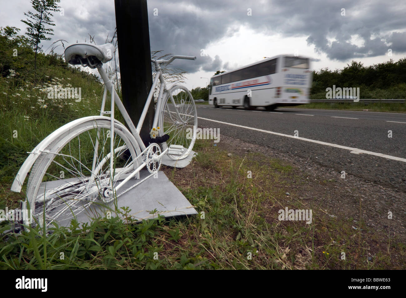 A Ghost Bike - a white painted cycle chained to the spot where a cyclist was killed in a road accident on the A23. Stock Photo