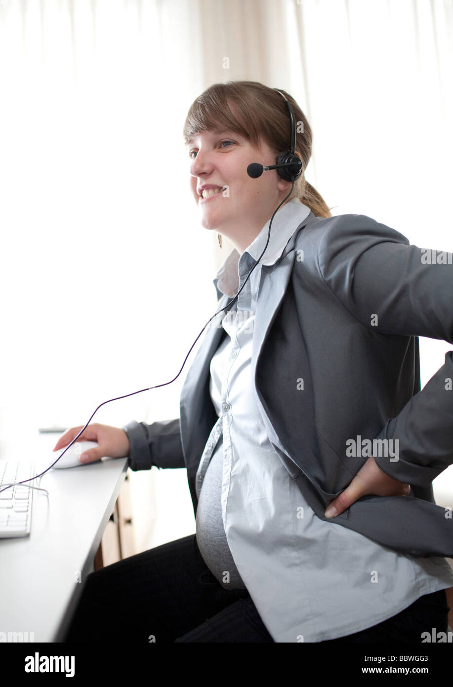 Pregnant woman working at a computer Stock Photo