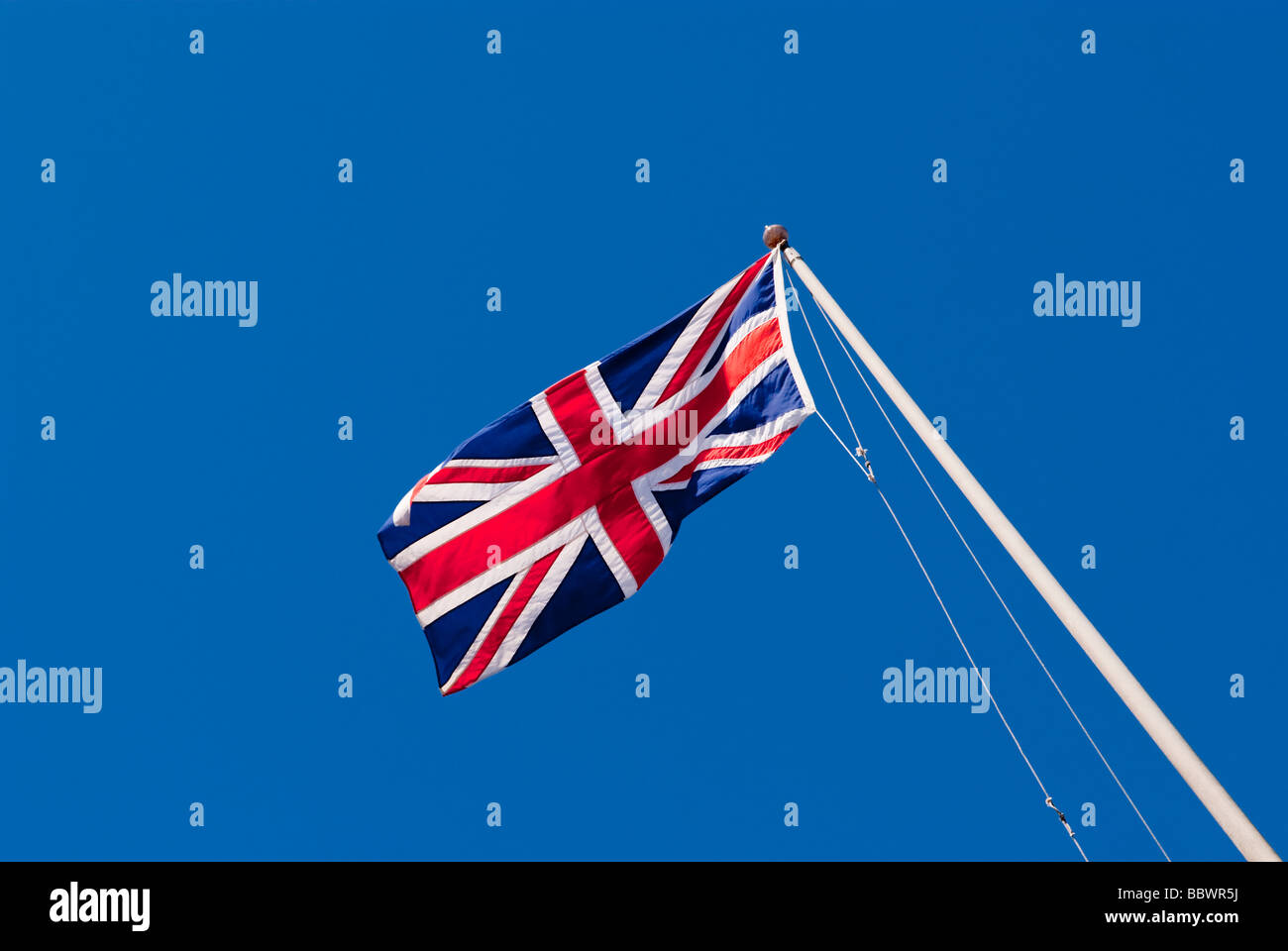 An English union jack flag flying against a deep blue sky in the Uk ...
