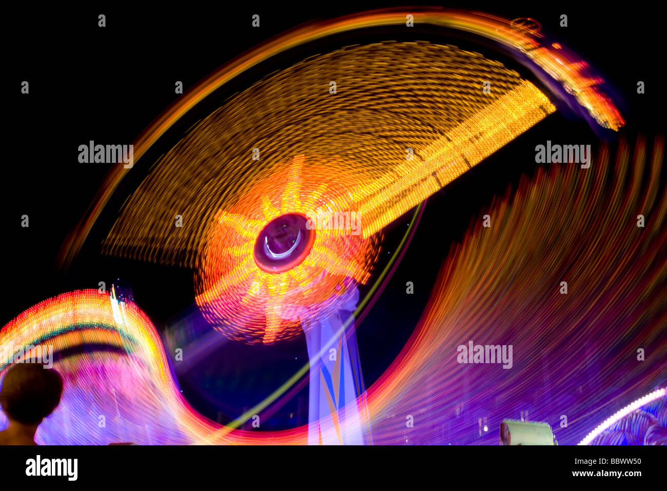 Motion Trail of Ferris Wheel at Night in Carnival Stock Photo