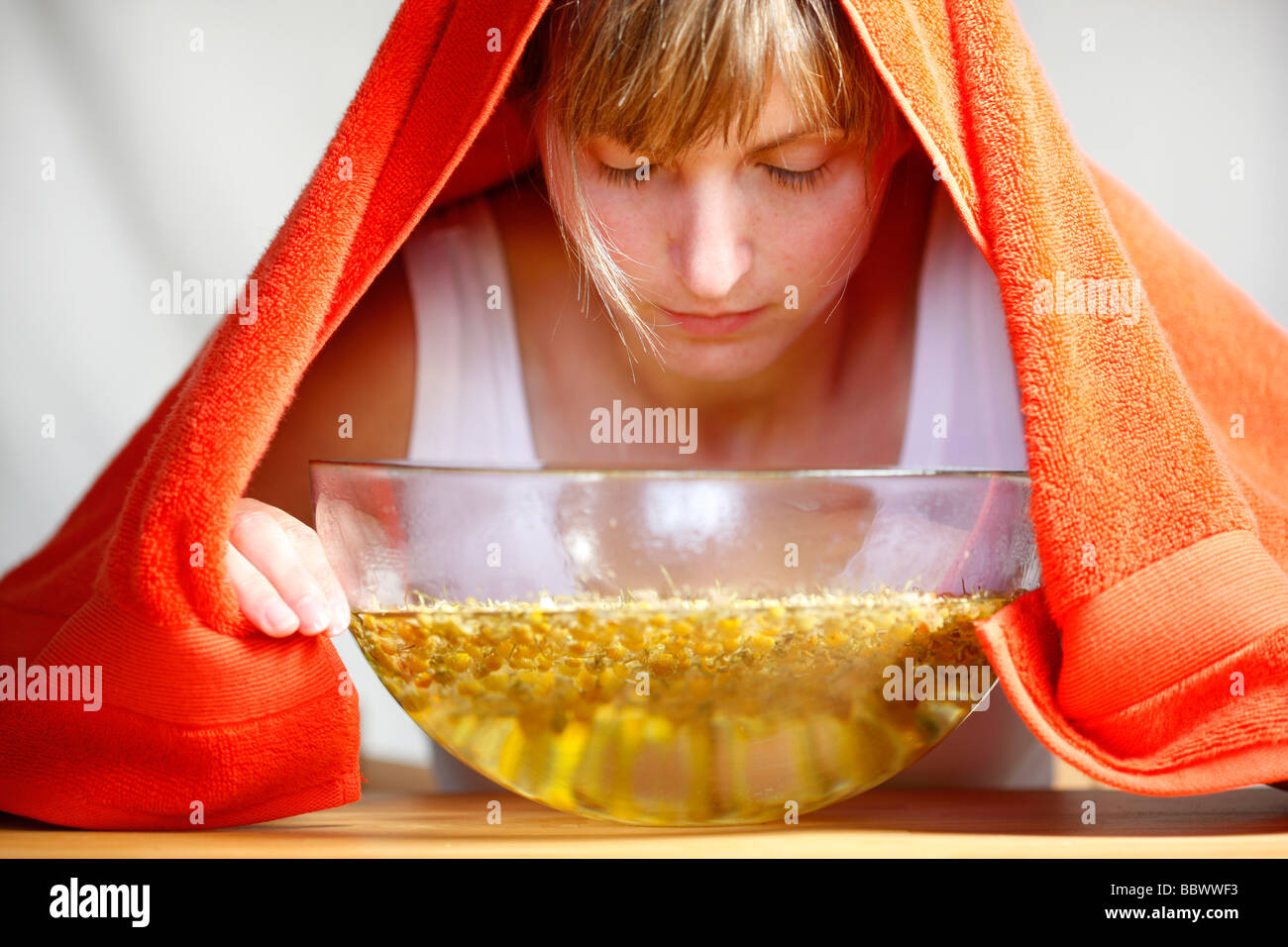 Woman inhaling the fumes of a camomile infusion against a cold Stock