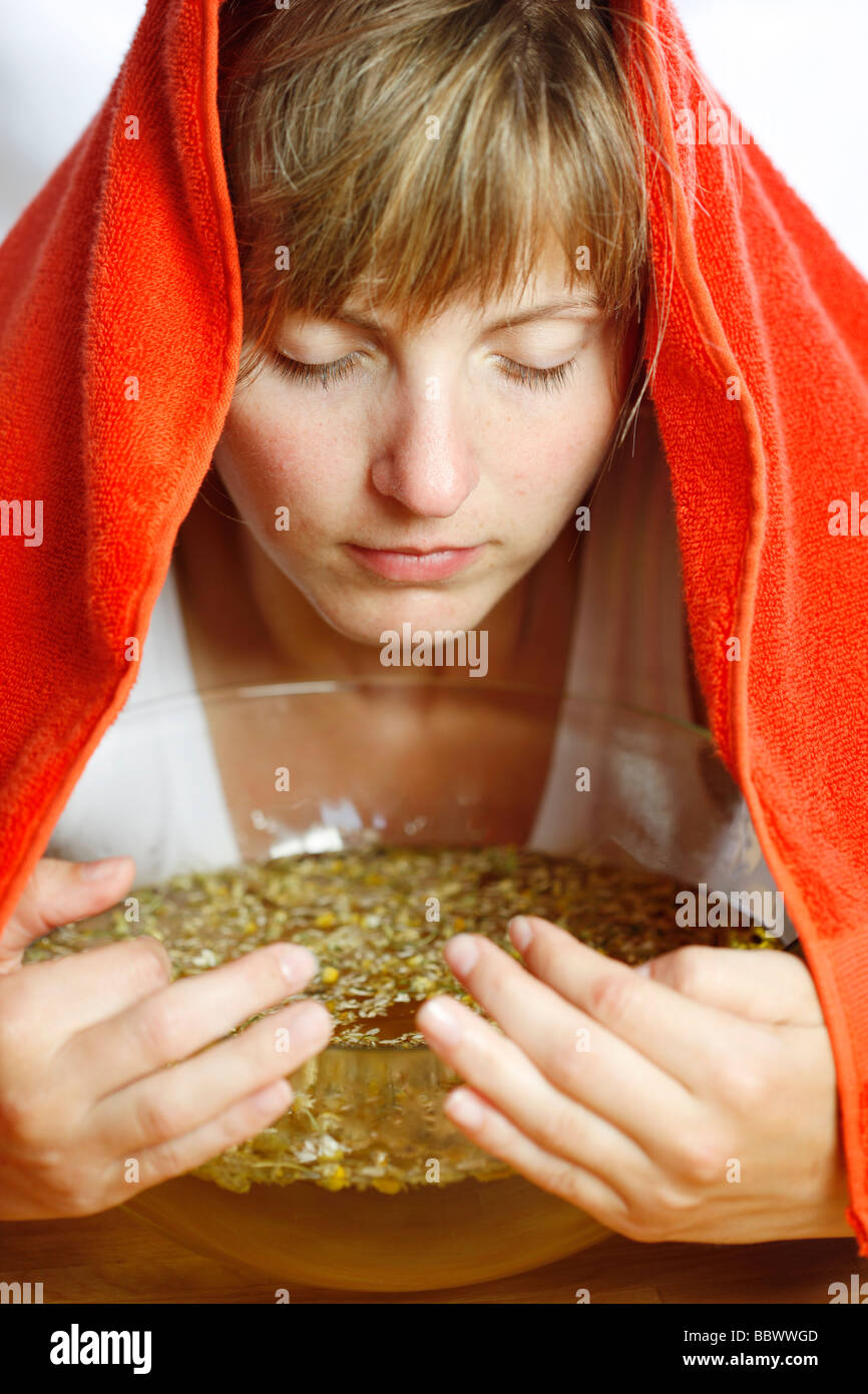 Woman inhaling the fumes of a camomile infusion against a cold Stock
