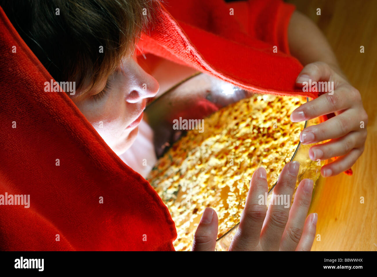 Woman inhaling the fumes of a camomile infusion against a cold Stock
