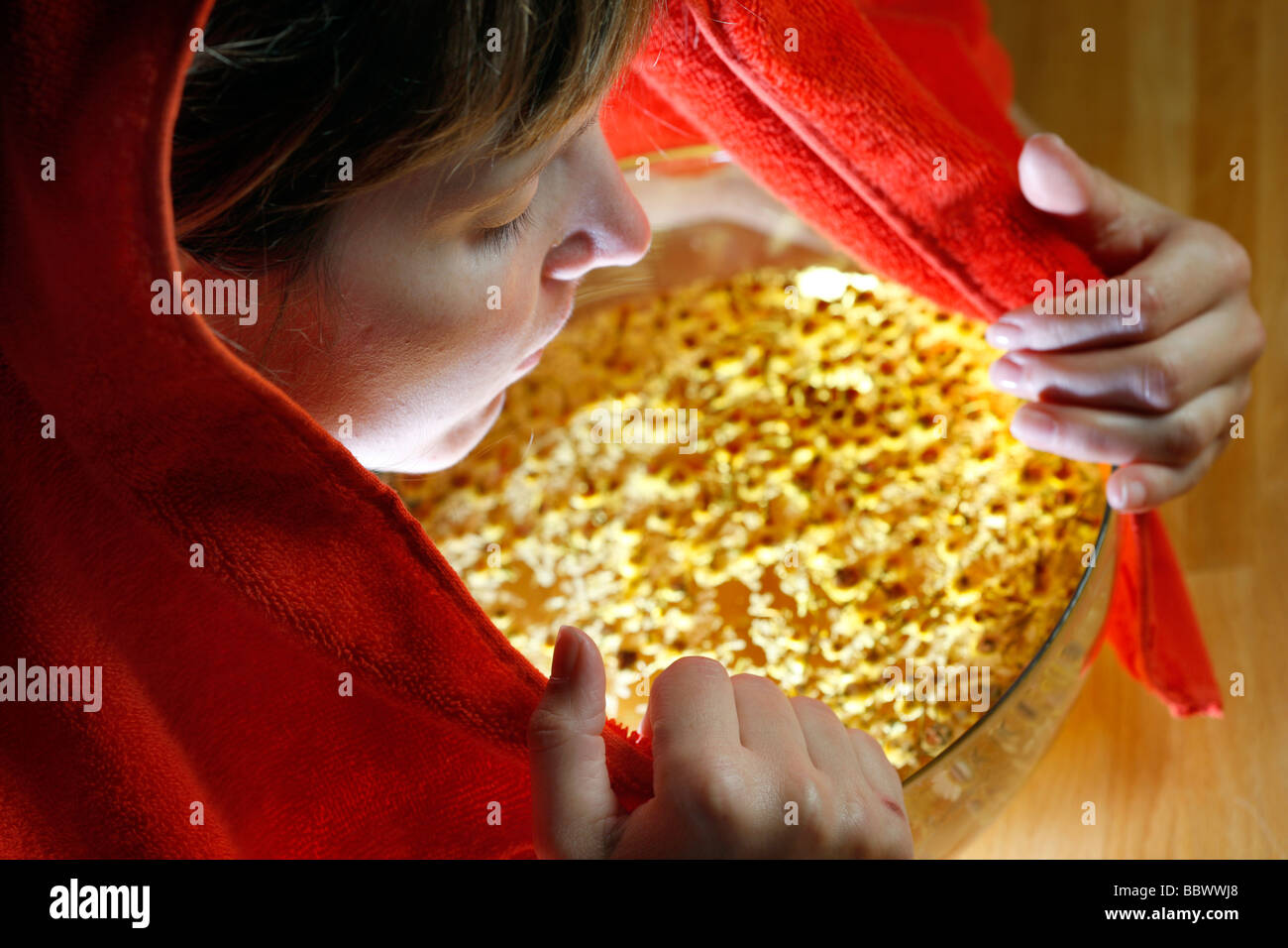 Woman inhaling the fumes of a camomile infusion against a cold Stock