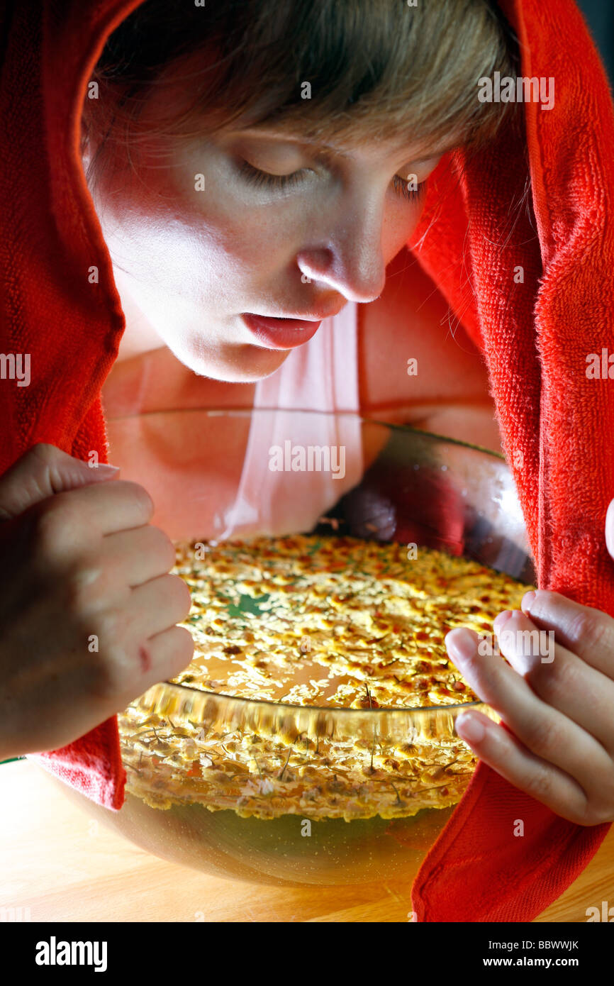 Woman inhaling the fumes of a camomile infusion against a cold Stock