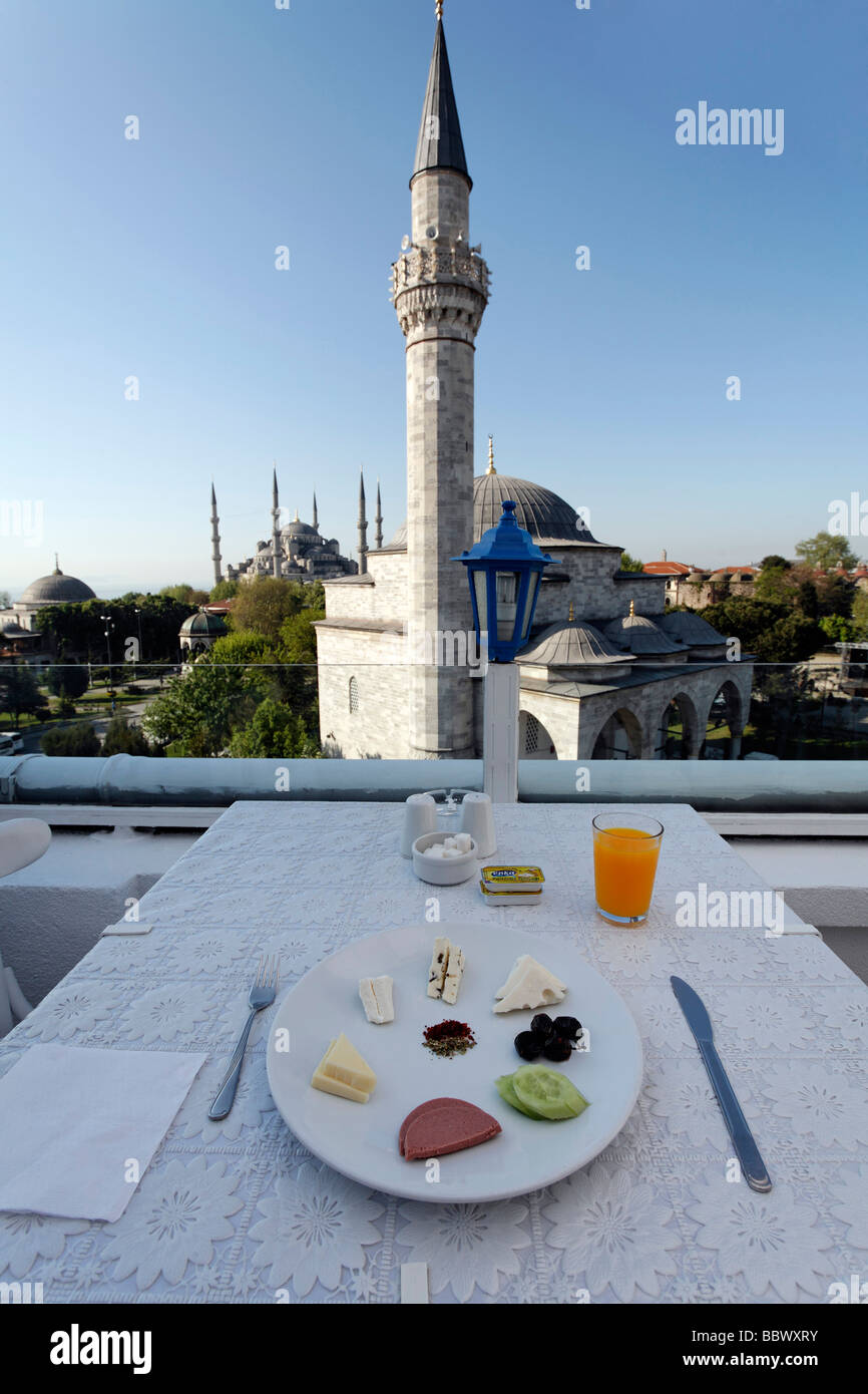 Breakfast table with plate on the roof terrace of a small hotel in Sultanahmet, view to Firuz Aga Mosque and Blue Mosque, Istan Stock Photo