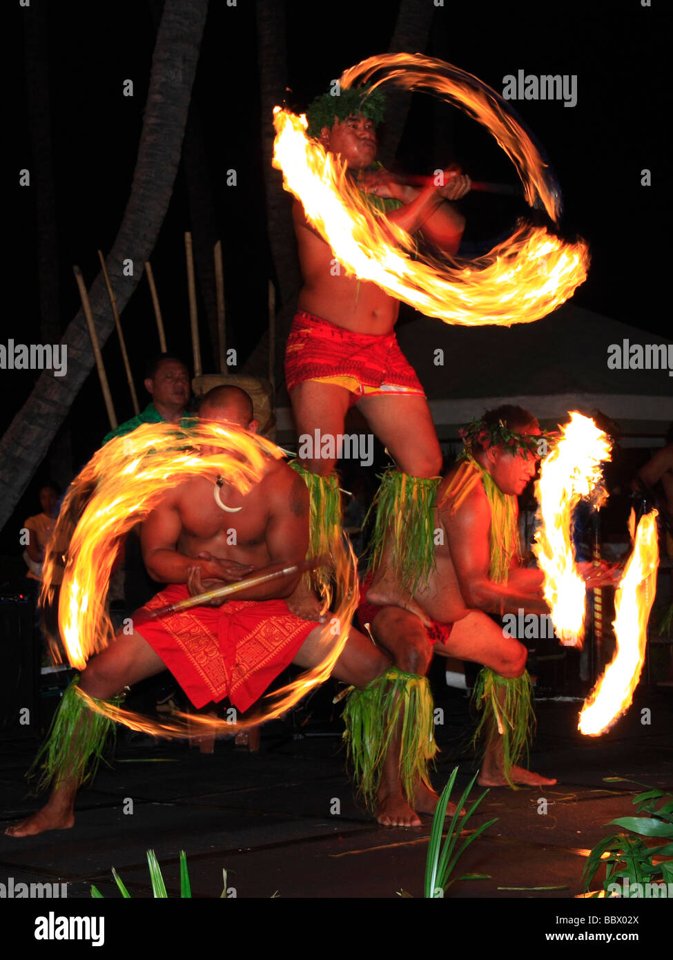 Traditional Hawaiian Fire Dance Performed By Three Mail Dancers Stock hawaiian-fire-dancer