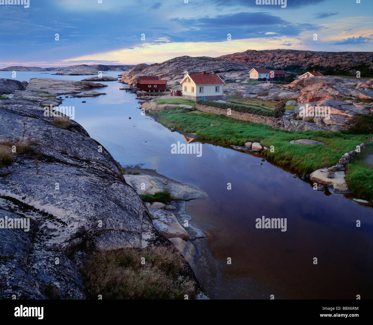 Houses on riverbank amidst rock formations Stock Photo